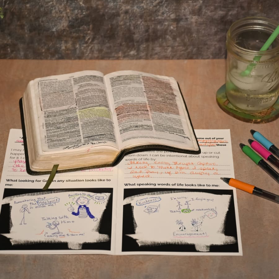 open bible on top of a bible study for teens workbook with a glass of ice tea