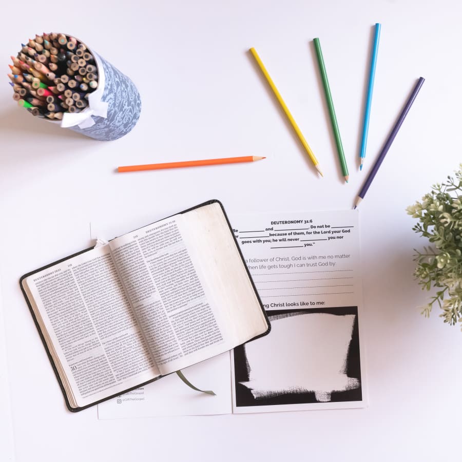 bible study for teens on white counter with open bible and colored pencils